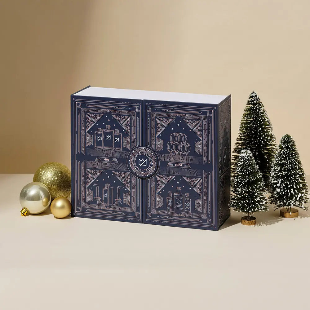 Advent calendar box with festive baubles and miniature snow-frosted trees.